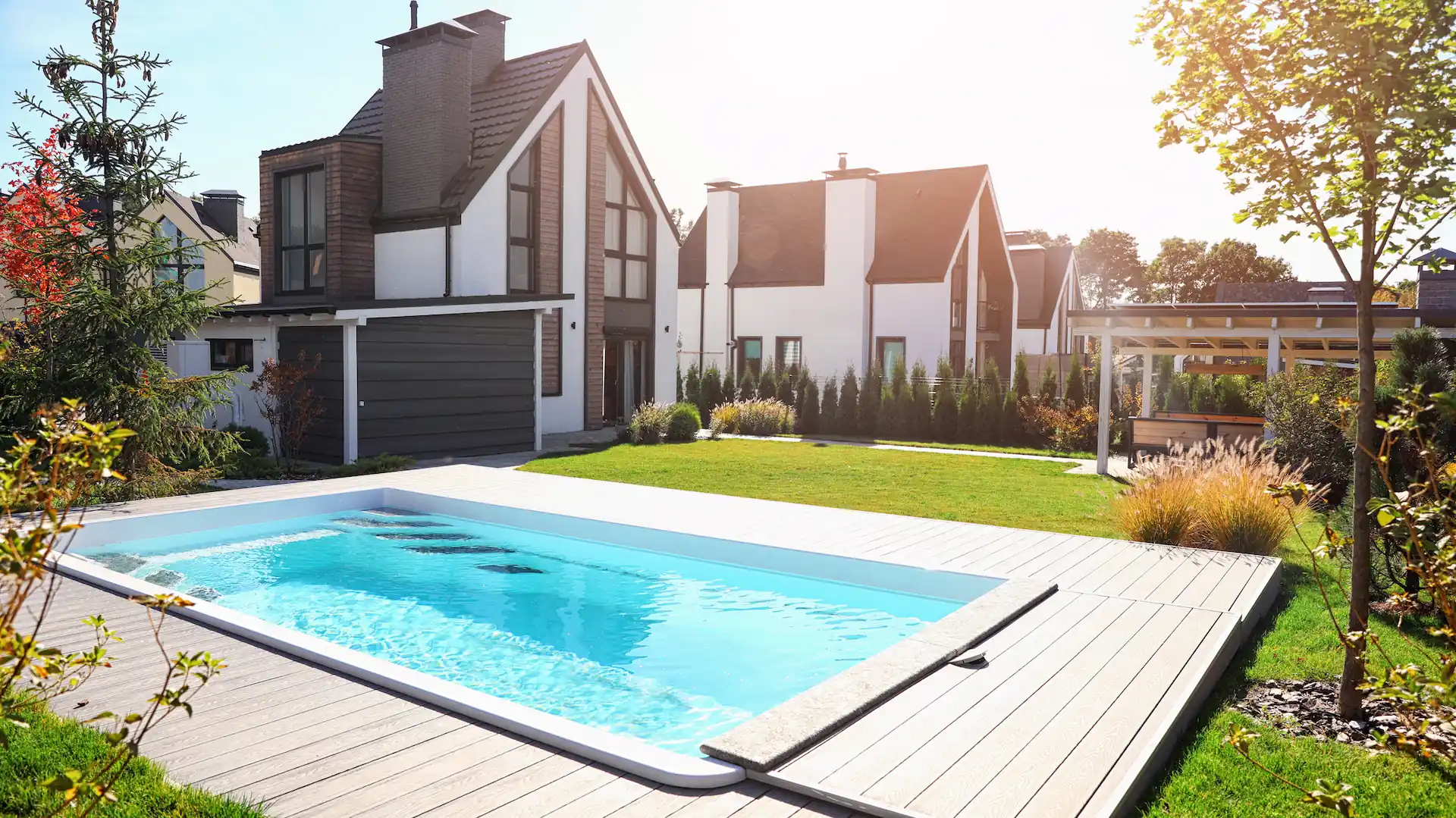 A modern house with an inground pool sitting in the sunlight. With pools such as these in the market, it's important for pool businesses to stay abreast of the latest pool equipment for their customers.