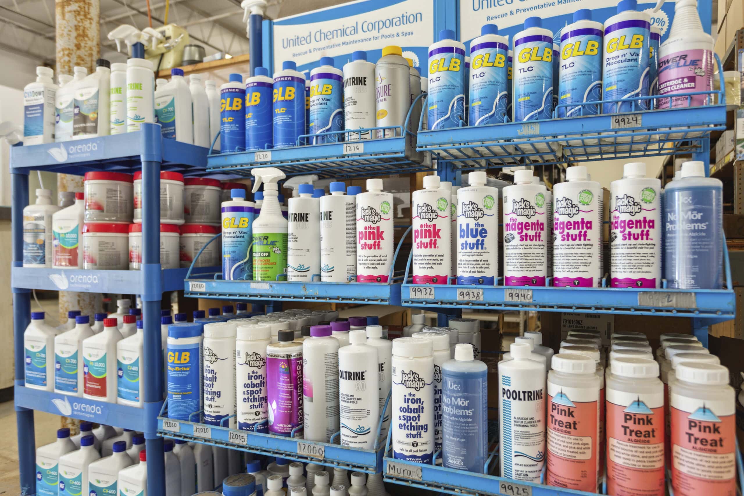 A variety of pool chemistry products on a shelf.