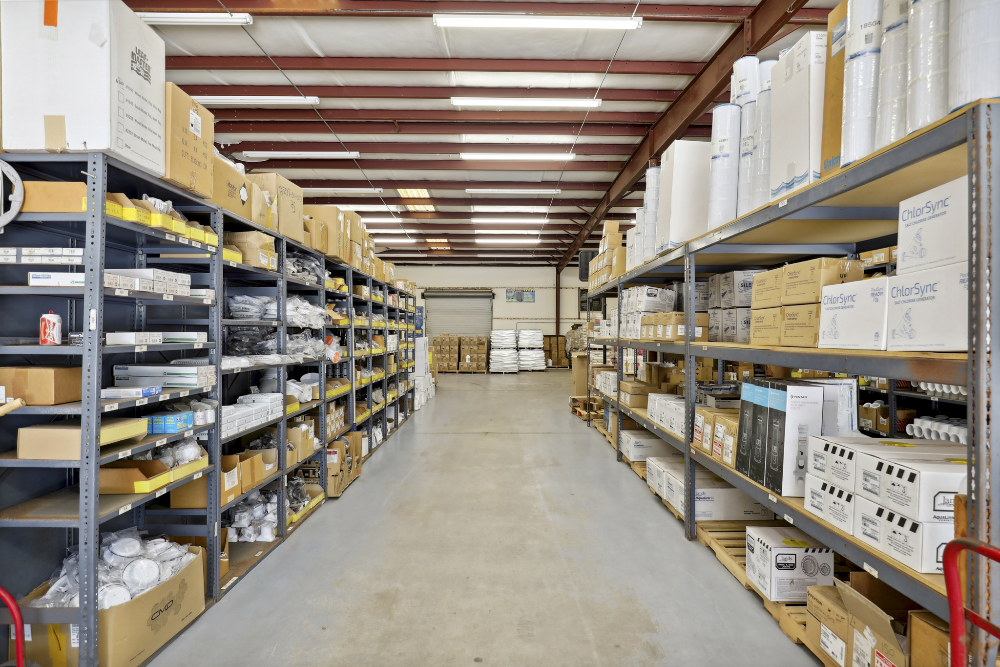 A warehouse or pool store with large shelving units full of pool supply products.